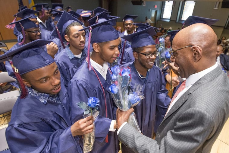 Boys Latin of Philadelphia’s founder David Hardy is presented blue roses by members of Class of 2017 during graduation ceremony on June 13, 2017. Ten years after Boys Latin of Philadelphia opened at least 84 percent of Boys Latin’s grads go to college and earn degrees.