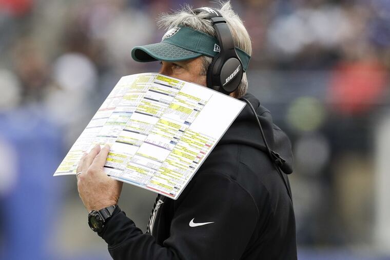 Eagles Head Coach Doug Pederson uses his play chart to cover his mouth against the New York Giants on Sunday, December 17, 2017. YONG KIM / Staff Photographer