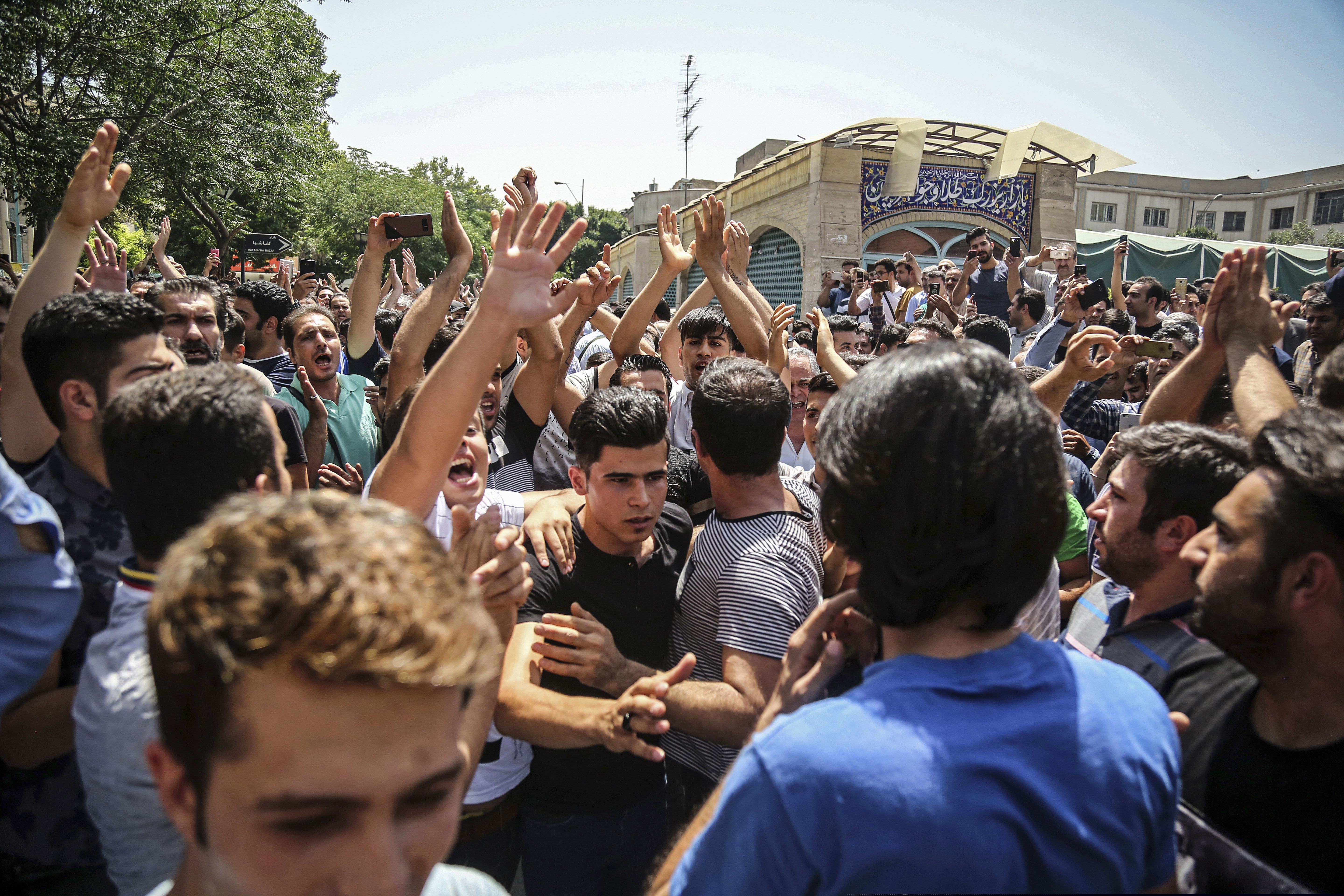 A group of protesters chant slogans at the main gate of the Old Grand Bazaar, in Tehran, Iran. On Saturday, Sept. 5, 2020, Iran broadcast the televised confession of a wrestler facing the death penalty after a tweet from President Donald Trump criticizing the case, a segment that resembled hundreds of other suspected coerced confessions aired over the last decade in the Islamic Republic.