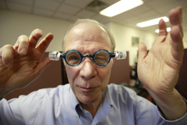 Edmond Dougherty models adjustable oil-filled glassed that could be marketed to developing countries. (David Swanson / Staff Photographer)