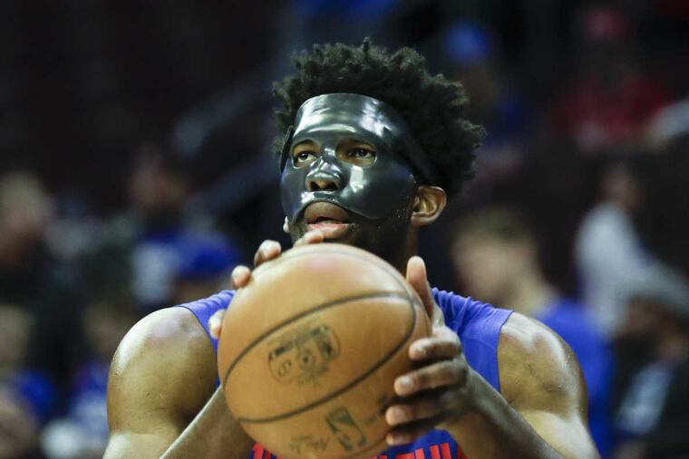 Sixers center Joel Embiid shoots the basketball with a mask on during warm-ups before the Sixers play the Milwaukee Bucks on Wednesday, April 11, 2018 in Philadelphia.