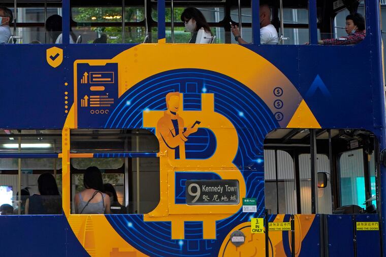 FILE - This May 12, 2021, file photo shows an advertisement for the cryptocurrency Bitcoin displayed on a tram in Hong Kong. Members of the online community Numerai are earning cryptocurrency for their stock-picking prowess.(AP Photo/Kin Cheung, File)