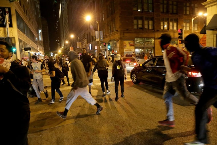 Protesters run after violence breaks out in downtown St. Louis on Sept. 17.