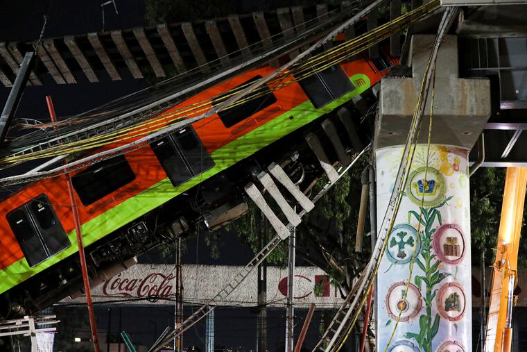 Subway cars lay at an angle on Tuesday after a section of Line 12 of the subway collapsed in Mexico City on Monday night.