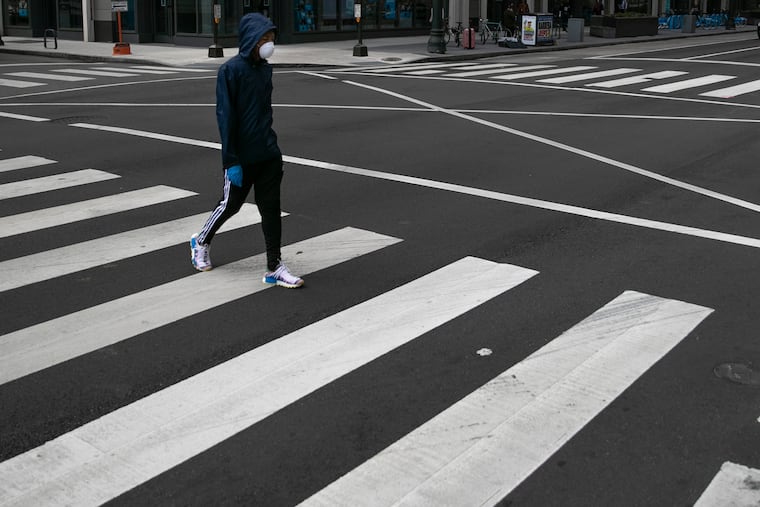 A pedestrian crosses Market Street at 11th in Philadelphia on April 08, 2020.