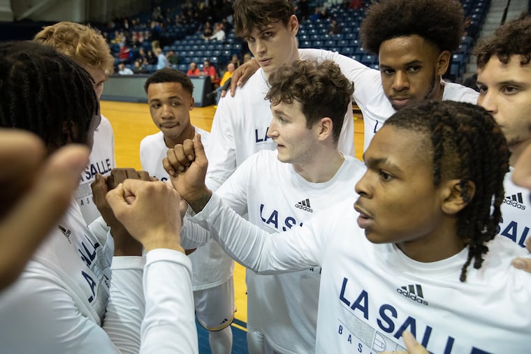 Tommy Gardler (center) and the La Salle team huddle before their game against Dayton on Tuesday.