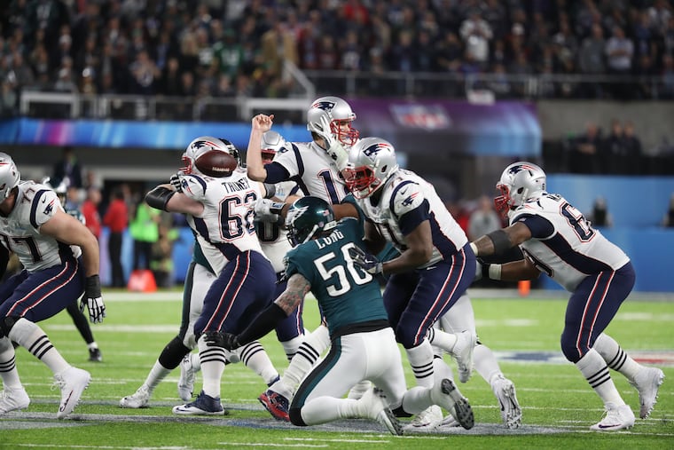 The ball comes free from Tom Brady's grasp after a hit by Brandon Graham. Derek Barnett recovered the fumble and the Eagles added a field goal. TIM TAI / Staff Photographer