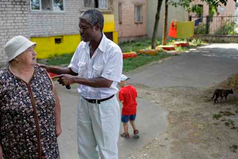 Councilman Jean Gregoire Sagbo chats with a constituent in his district of Novozavidovo, north of Moscow. A native of Benin,he arrived in Moscow to study in 1982. Seven years later, he moved to the town his wife is from to be closer to his in-laws.