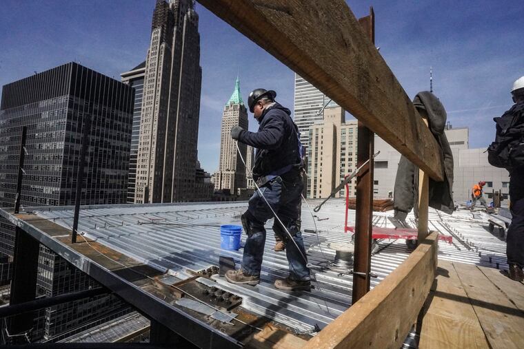 Construction workers install roofing on a high rise in Manhattan's financial district last month.