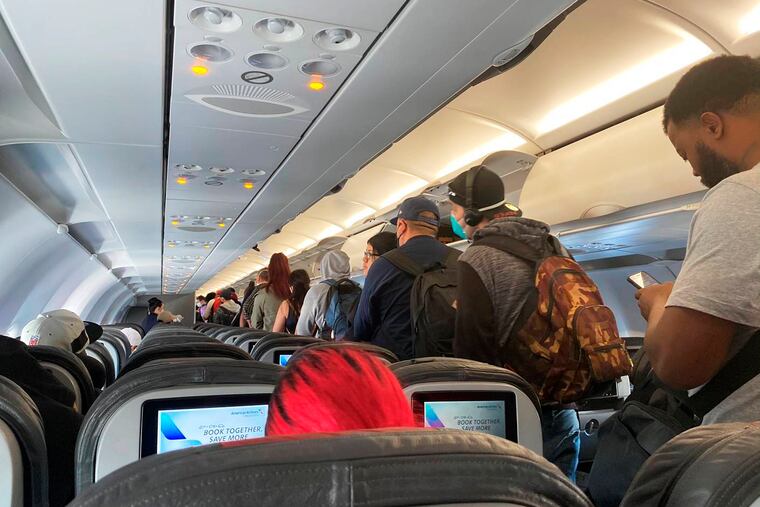 Passengers get off a Monday American Airlines flight airplane after they landed at Los Angeles International Airport. Airlines are going to start requiring passengers wear masks.