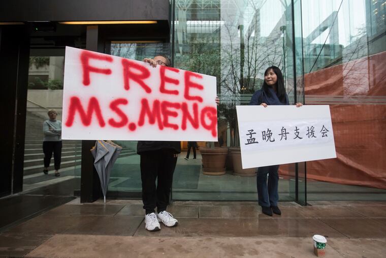 Supporters hold signs outside the British Columbia Supreme Court in Vancouver during the third day of a bail hearing for Meng Wanzhou, the chief financial officer of Huawei Technologies, on Tuesday December 11, 2018. (Darryl Dyck/The Canadian Press via AP)