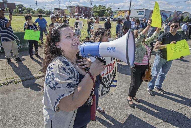 Erika Almiron of Juntos uses a bullhorn to address Congreso president Carolina Cabrera DiGiorgio from across the street from the Congreso office. MICHAEL BRYANT / Staff Photographer