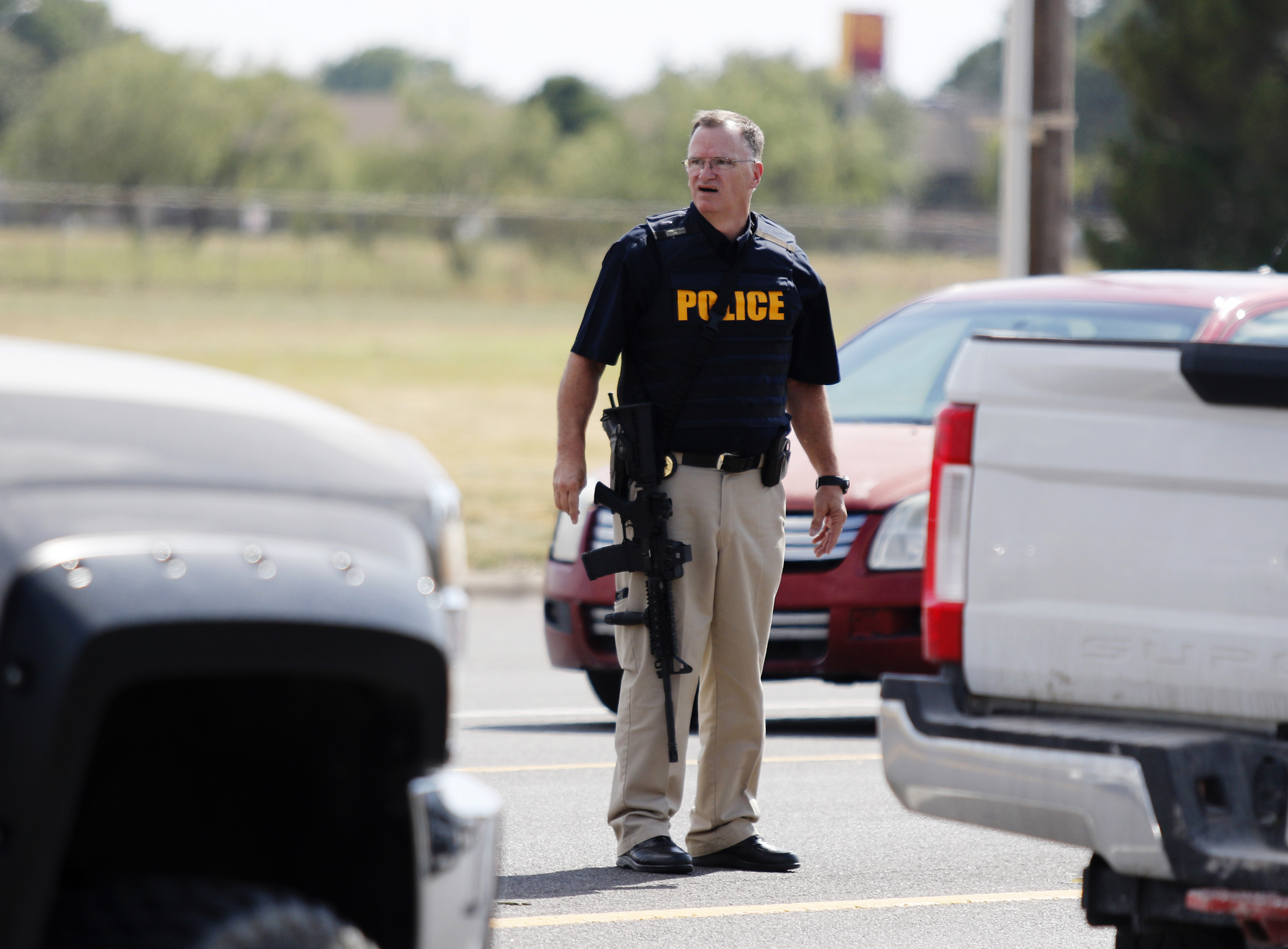 A law enforcement officer stands in the middle of the 5100 block of E. 42nd Street in Odessa, Texas, Saturday, Aug. 31, 2019, following a shooting at random in the area of Odessa and Midland. Several people were dead after a gunman who hijacked a postal service vehicle in West Texas shot more than 20 people, authorities said Saturday. The gunman was killed and a few law enforcement officers were among the injured.