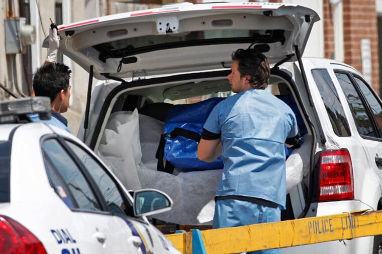 Medical Examiner’s Office workers load human remains found in an abandoned house in Grays Ferry into a vehicle for transport to their office in West Philadelphia. (Alejandro Alvarez/Staff Photographer)