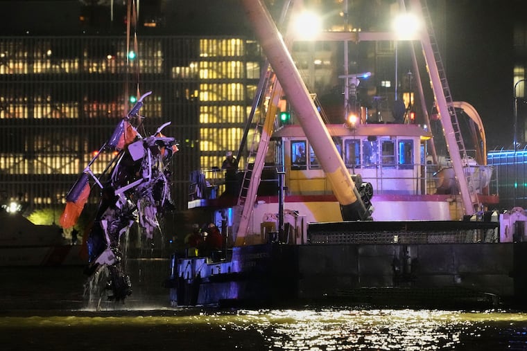 A crane lifts the wreckage of a helicopter that crashed into the Hudson River on Thursday, April 10, 2025, in Jersey City, N.J.