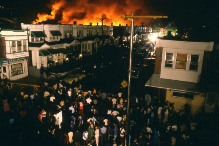 A crowd watches as Osage Ave. erupts in flames, killing 11, during the 1985 MOVE confrontation in West Philadelphia.(File photo)