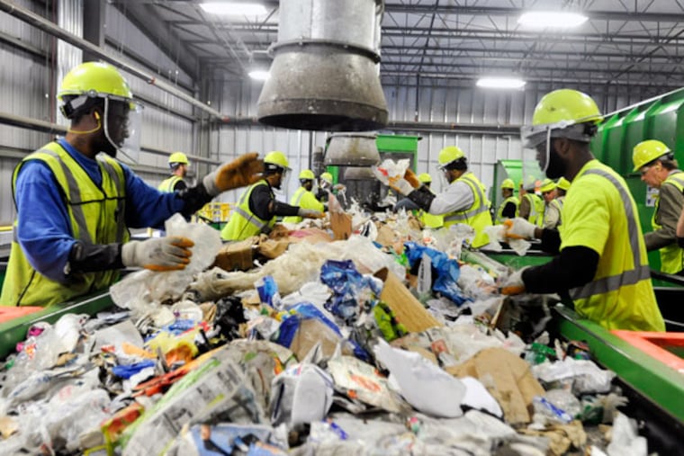 In an expensive process, workers remove by hand nonrecyclables from items that can be recycled. (RON TARVER/File Photo)
