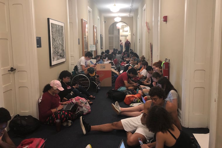 Dozens of Swarthmore College students sit outside the school president's office on Thursday, May 2. They want her to permanently ban two fraternity organizations from campus.