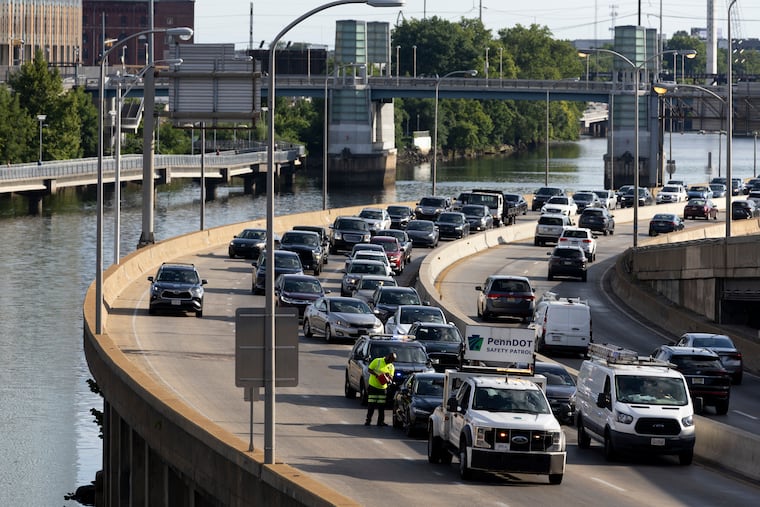 Traffic backs up on I-76 westbound as a PennDOT Safety Patrol worker puts gas into a disabled vehicle on the highway in Philadelphia on Tuesday, July 2, 2024.