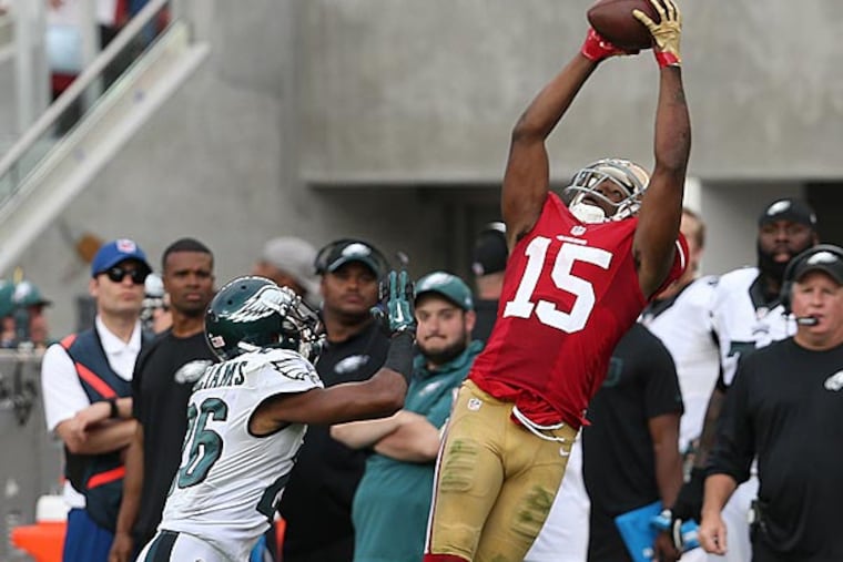 The 49ers' Michael Crabtree (right) catches a pass as the Cary Williams defends. (David Maialetti/Staff Photographer)