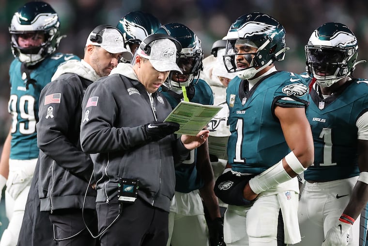 Philadelphia Eagles offensive coordinator Kellen Moore (left) talks with quarterback Jalen Hurts last Thursday night. Hurts is averaging 21.8 passes per game in the Eagles' six-game winning streak.
