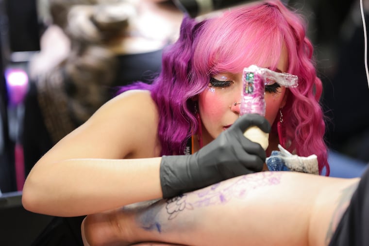 Nicole “Mars” Lenz of Altamonte Springs, Fla., works on a tattoo at the 2024 Philadelphia Tattoo Arts Festival at the Pennsylvania Convention Center in Philadelphia.