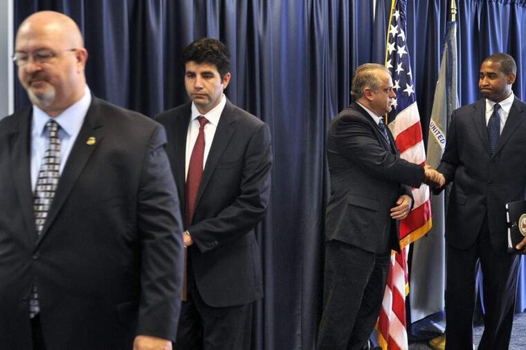 U.S. Attorney Zane David Memeger (right) is congratulated by FBI Special Agent-in-Charge George C. Venizelos after announcing indictments against five people. At left is Department of Education Special Agent-in-Charge Steven Anderson and Assistant U.S. Attorney Anthony Kyriakakis.
TOM GRALISH / Staff Photographer