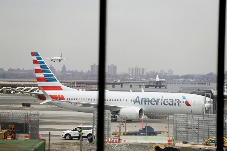 FILE - In a March 13, 2019 file photo, an American Airlines Boeing 737 MAX 8 sits at a boarding gate at LaGuardia Airport in New York. American Airlines expects to take a $1 billion hit from two things it didn't expect when 2019 started: That its newest Boeing jet would be grounded for months after two deadly crashes, and that oil prices would rise. (AP Photo/Frank Franklin II, File)