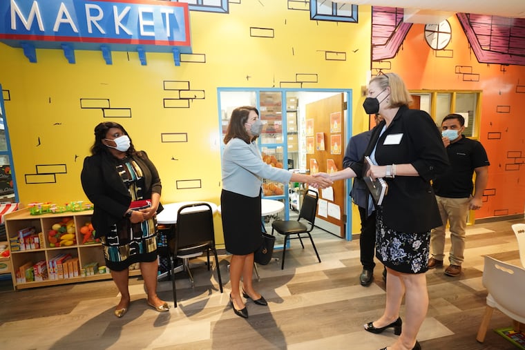 Assistant Secretary of State Julieta Valls Noyes (center) greets Margaret O’Sullivan, the executive director of Nationalities Service Center, at the NSC office in Philadelphia on Monday. The secretary visited the resettlement agency on the anniversary of the fall of Kabul, which brought hundreds of Afghans to start new lives here in the metro region.