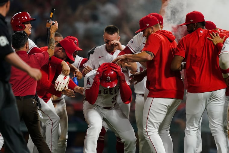 The Angels surround Taylor Ward (3) after they beat the Houston Astros in 10 innings on Saturday.