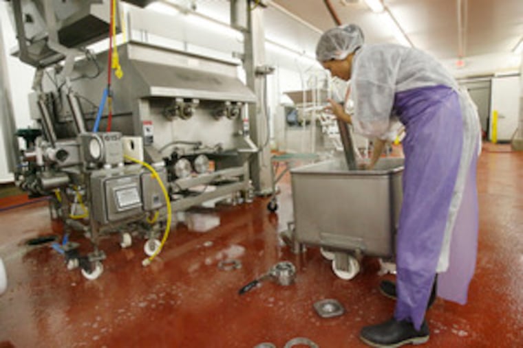 After a day of production, machine operator Litza Flores cleans piping from the cooker on the left that blends ingredients and then slow-cooks the dog food at Freshpet's Quakertown plant.