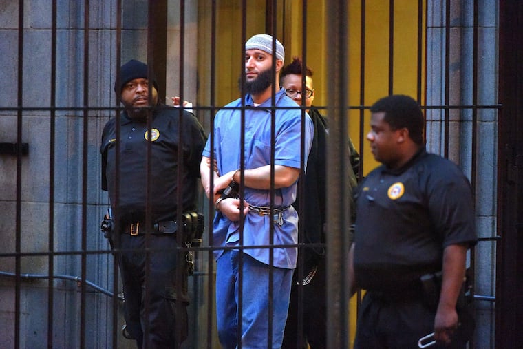 Officials escort "Serial" podcast subject Adnan Syed from a courthouse in 2016, following hearings for a retrial in Baltimore.