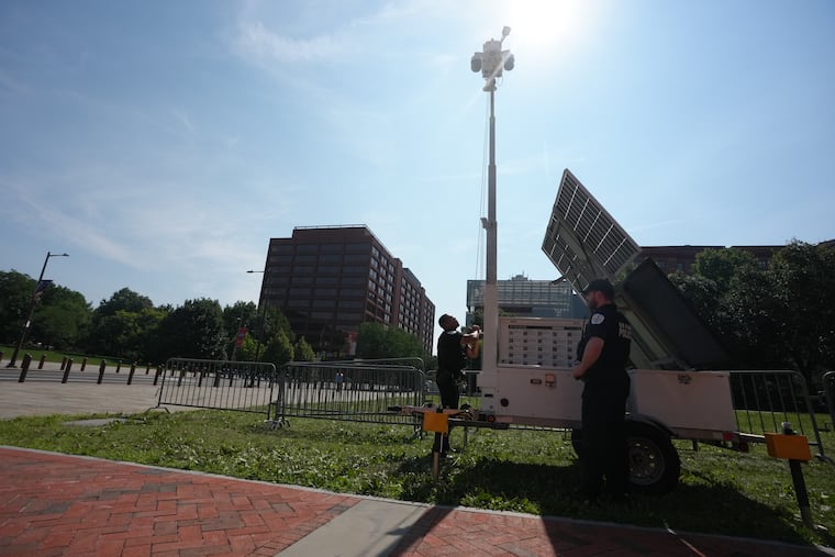 U.S. Park Police raise a security camera at the President's House site, where new panels have been installed, in Philadelphia, July 15, 2026. Historians and advocates have criticized the panels for minimizing George Washington's role as an enslaver.