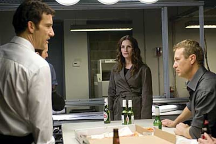 "Duplicity," from the writer/director of “Michael Clayton,” stars (from left) Clive Owen, Julia Roberts, Oleg Stefan and Kathleen Chalfant.