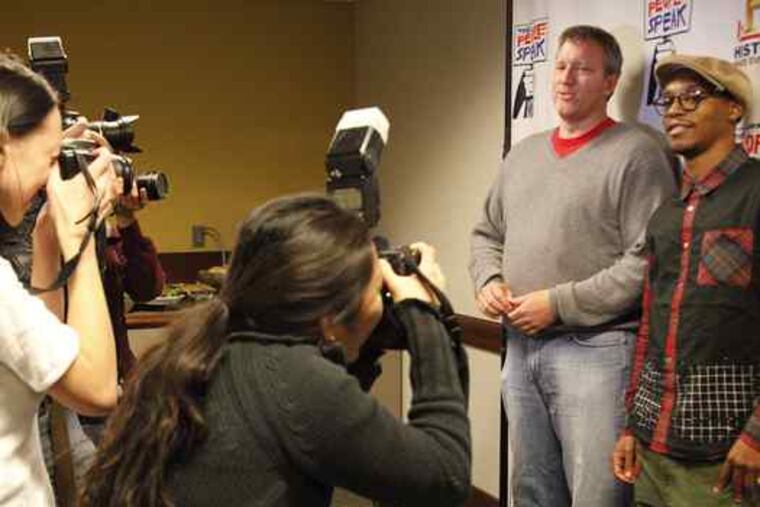 Chris Moore (left), executive producer of the film "The People Speak,"and hip-hop artist Lupe Fiasco pose for pictures at Penn's Irvine Auditorium. They were in town Tuesday for The People Speak College Tour, where they showed highlights from the film and took questions.