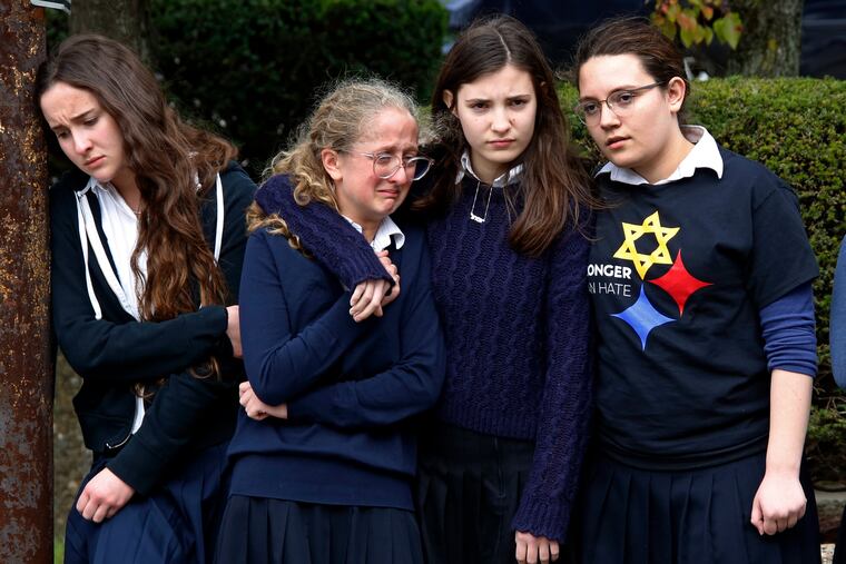 Students from the Yeshiva School in the Squirrel Hill neighborhood of Pittsburgh pay their respects as the funeral procession for Dr. Jerry Rabinowitz passes their school. Rabinowitz was one of several people killed in a mass shooting while worshipping at the Tree of Life synagogue last October.