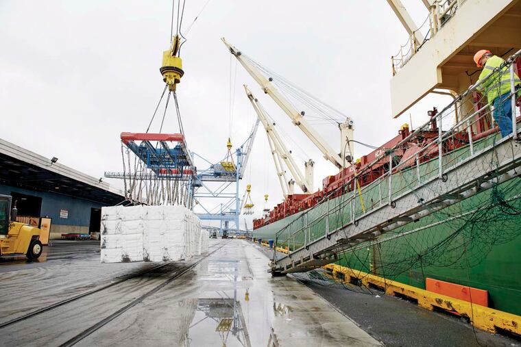 Rocky Lamb (right), a stevdores foreman,<MC> watches over workers unloading bales of wood pulp from Brazil at the Tioga Marine Terminal. TRACIE VAN AUKEN
