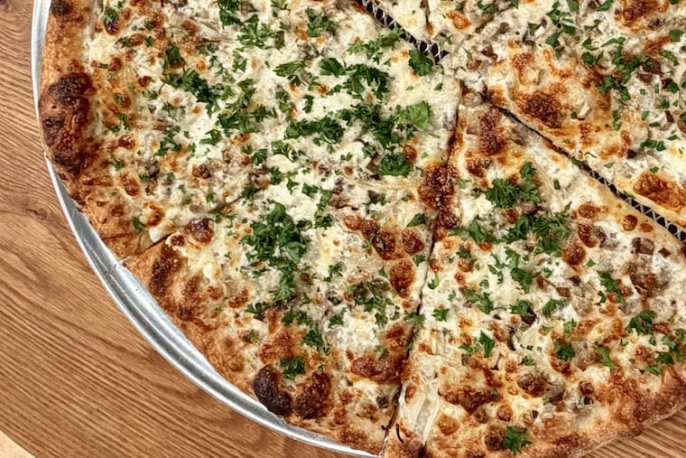 The mushroom pizza, with creme fraiche, scamorza, mozzarella, and onions, at Liguria Pizzeria.
