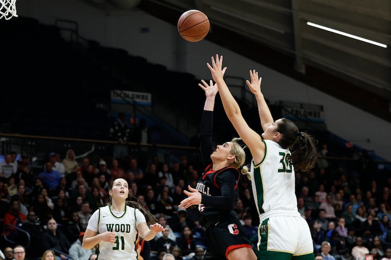 Archbishop Carroll’s Alexis Eberz shoots a layup between Archbishop Wood’s Emily Knouse (30) and Sophia McDonald in the first quarter on Feb. 17.
