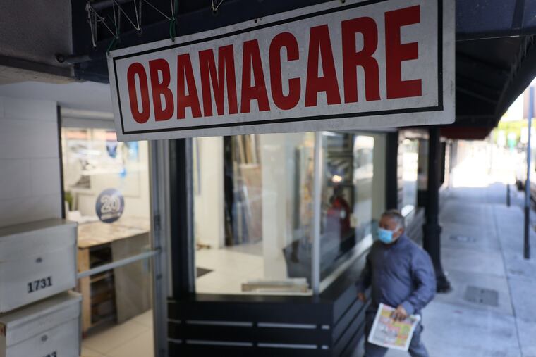 A pedestrian walks past the Leading Insurance Agency, which offers plans under the Affordable Care Act (also known as Obamacare) on Jan. 28, 2021 in Miami, Florida.