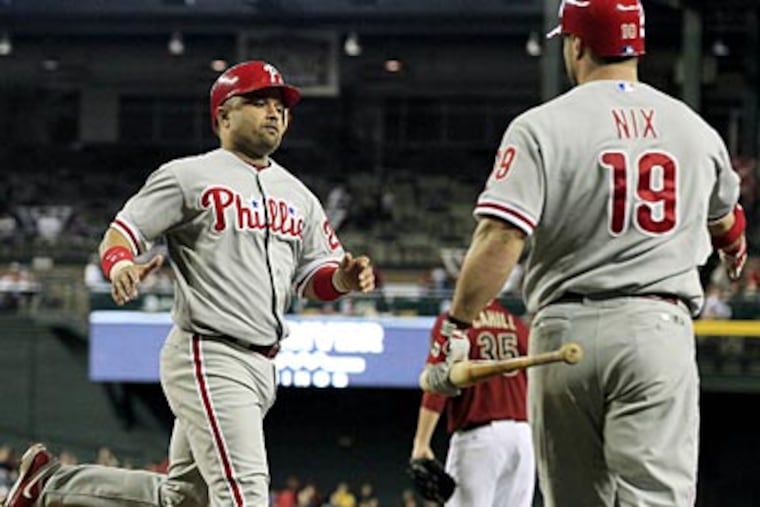 Placido Polanco celebrates with Laynce Nix after scoring in the first inning on Wednesday. (Ross D. Franklin/AP)