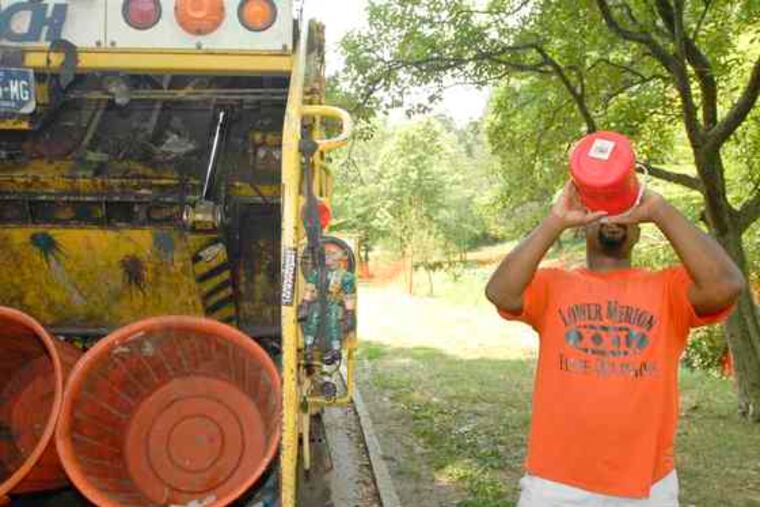 Louis Williams gulps from his half-gallon jug between trash pickups. He and his crew estimate they walk as much as 10 milesa day lifting heavy cans. Amid a heat wave, precision is even more important as they try to finish in the "cooler" hours.