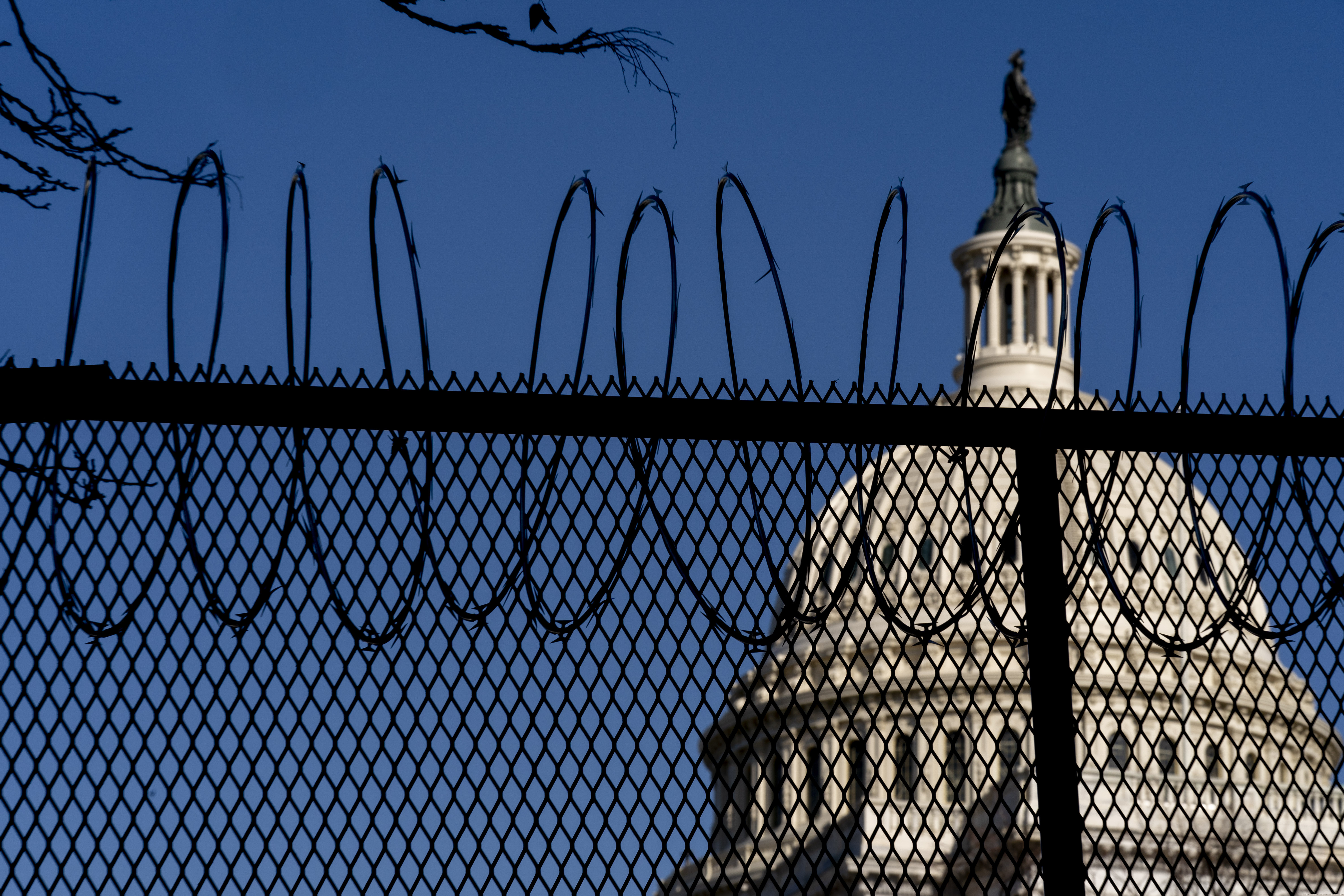 The Dome of the Capitol Building is visible through razor wire installed on top of fencing on Capitol Hill on Thursday.