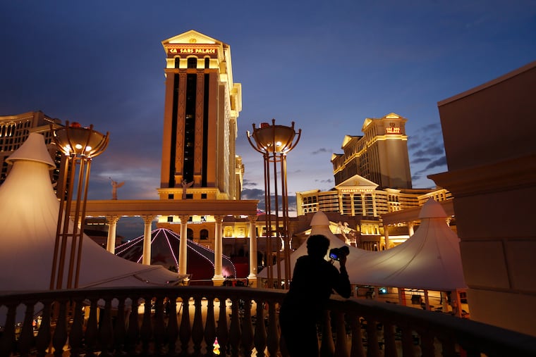 A man takes pictures of Caesars Palace hotel and casino in Las Vegas, Jan. 12, 2015.