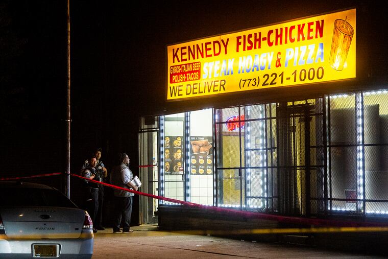 In this Friday, May 31, 2019 photo, Chicago Police investigate the scene where a man was shot inside a restaurant in the South Shore neighborhood of Chicago. (Tyler LaRiviere/Chicago Sun-Times via AP)