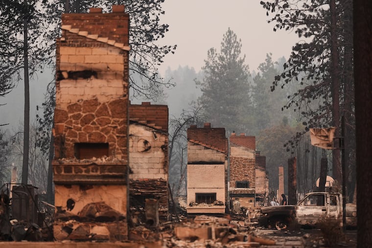 Chimneys are the only structures remaining in a residential neighborhood after a wildfire hit the northern part of Spokane, Wash., Monday, Aug. 3, 2026.