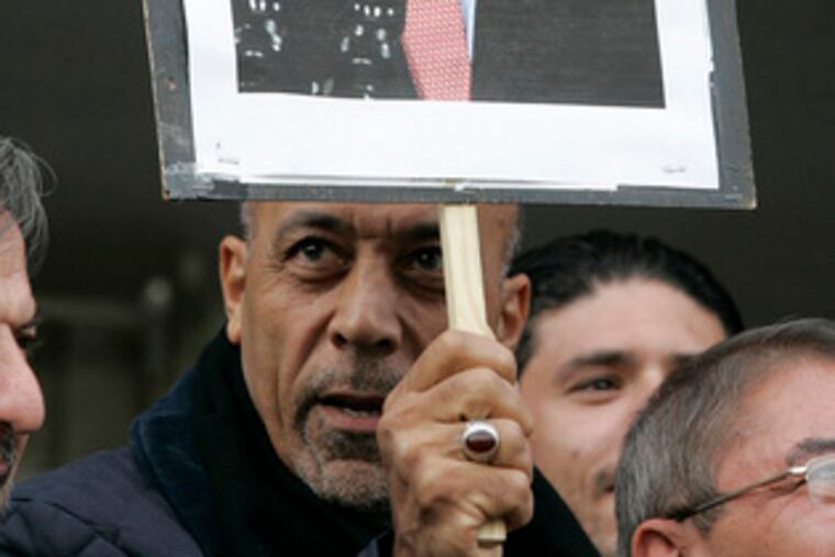 At a rally in Jordan in support of shoe-throwing journalist Muntadhar al-Zeidi, a sign illustrates the Iraq incident.