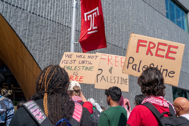 People hold up signs during a pro-Palestine rally and march on Temple University's campus on Aug. 29.
