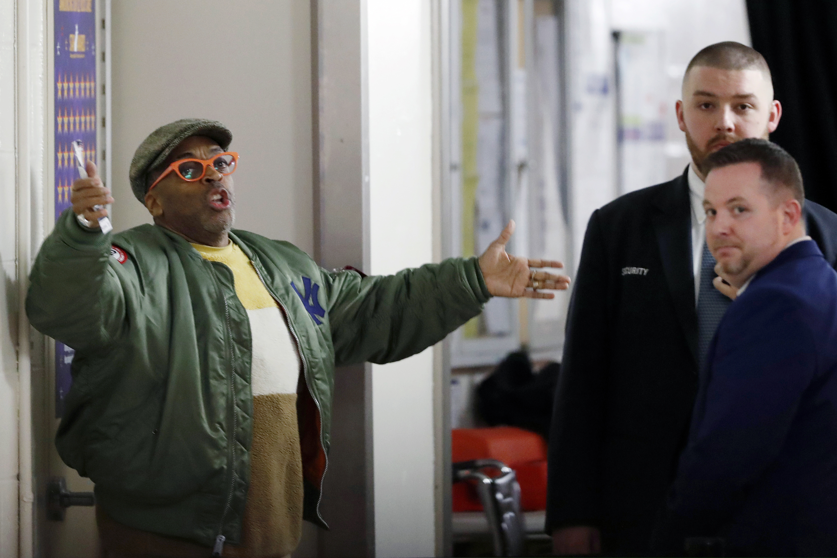 Director Spike Lee, left, gestures in a hallway on the event level at MSG while arguing with security officers who didn't want to permit him to access his courtside seat before the start of an NBA basketball game between the Knicks and the Rockets on Monday.
