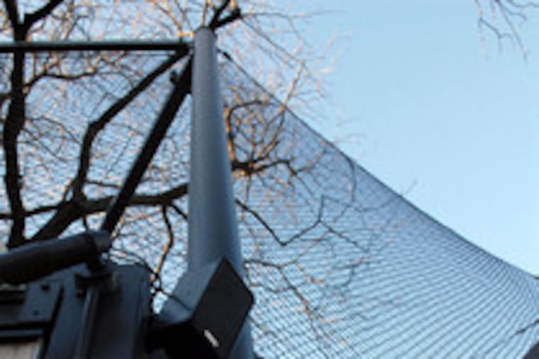 The wire mesh around the lions and tigers rises 16 feet and angles back in for 3 feet. It is effective because of both the tensile strength of the steel and the flexibility of the netting .